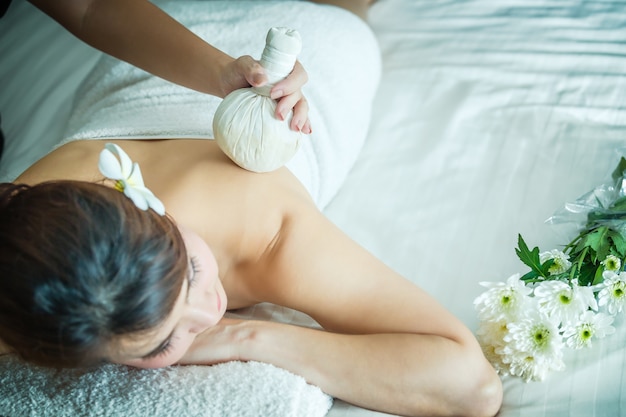 Schließen Sie herauf Porträt der attraktiven Frau, die ayurvedic pinda Massage an zurück hat.