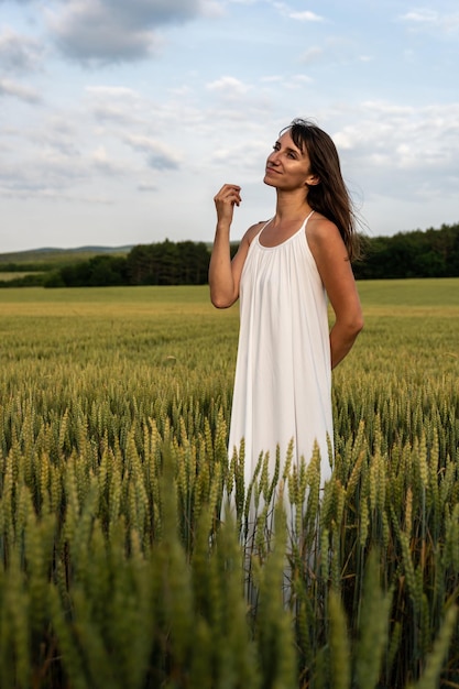 Schließen Sie herauf Porträt der glücklichen jungen Brunettefrau im weißen Kleid an