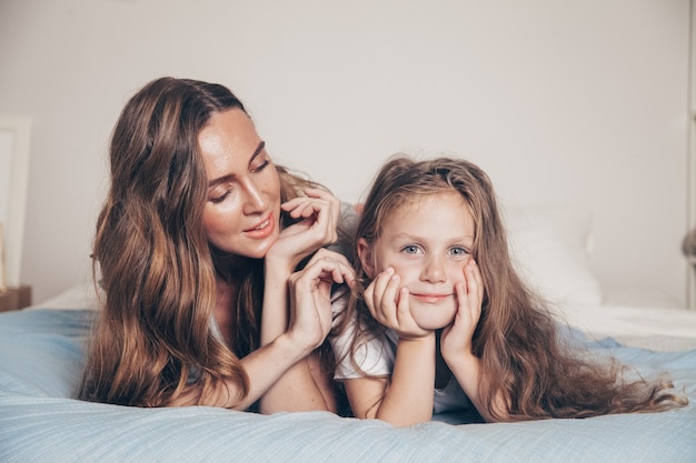 Schließen Sie herauf Porträt der glücklichen liebenden Familie liegend, die entspannend genießt im Schlafzimmer zusammen.