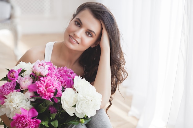 Schließen Sie herauf Porträt der jungen schönen Frau mit Blumen drinnen