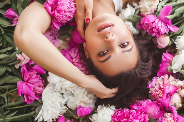 Schließen Sie herauf Porträt der jungen schönen Frau mit Blumen drinnen