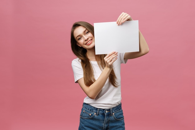 Schließen Sie herauf Porträt der positiven lachenden Frau, die weißes großes Modellplakat lächelt und hält