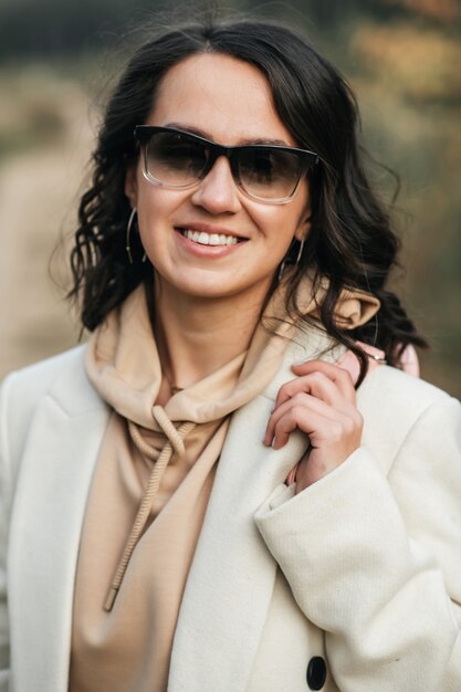 Schließen Sie herauf Porträt des brünetten Mädchens in der Sonnenbrille im Wald