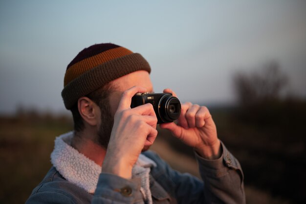 Schließen Sie herauf Porträt des jungen Mannes, der Foto durch Digitalkamera nimmt