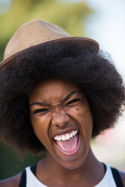 Foto schließen sie herauf porträt einer schönen jungen afroamerikanerfrau, die an einem schönen sonnigen tag lächelt und aufschaut