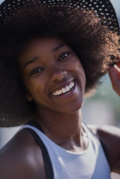 Schließen sie herauf porträt einer schönen jungen afroamerikanerfrau, die an einem schönen sonnigen tag lächelt und aufschaut