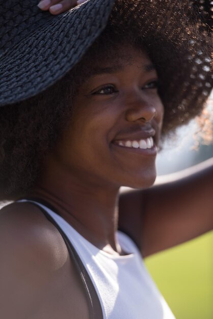 Schließen sie herauf porträt einer schönen jungen afroamerikanerfrau, die an einem schönen sonnigen tag lächelt und aufschaut