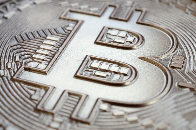 Schließen Sie herauf Schuss eines physischen Bitcoin mit einer glänzenden Entlastungsoberfläche gemacht der Schokolade