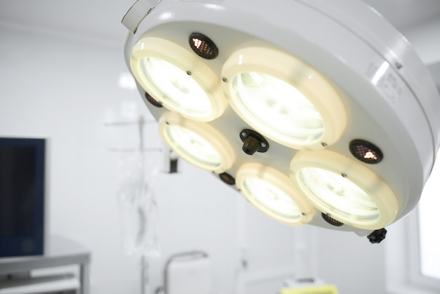 Foto schließen sie herauf schuss von einer chirurgischen lampe im operationssaal am krankenhaus-copysapce-ausrüstungs-technologie-lichtchirurgie-medizin-medizinisches klinisches konzept.