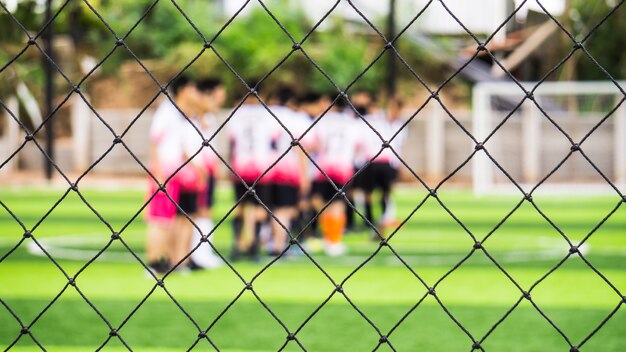 Schließen Sie herauf Zaun des Hallenfußballfeldes des künstlichen Grases für schützen Sie den Ball über Fußballplatz.