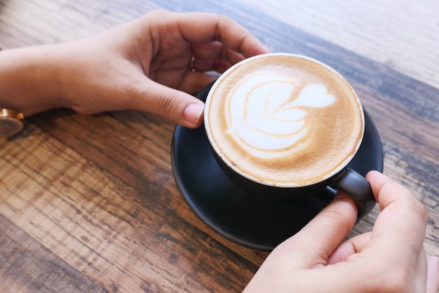 Schließen Sie oben auf Frauenhänden, die Kaffeetasse halten