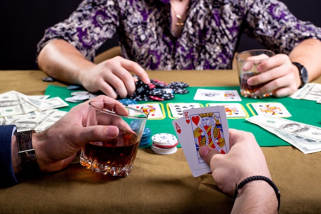 Schließen Sie oben auf Karten in den Händen des Mannes am Pokertisch