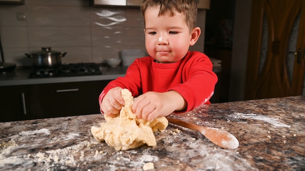 Schließen Sie oben auf kleinen Jungen, der in der Küche kocht