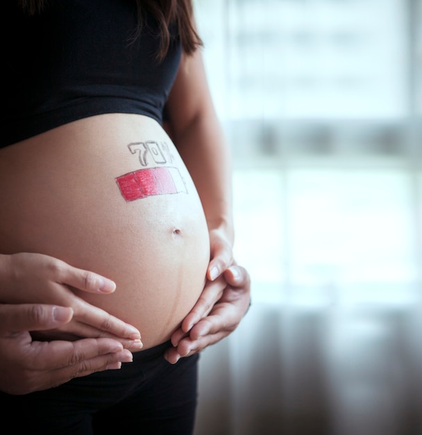 Schließen Sie oben auf schwangerem Bauch mit Ladebatteriekonzept