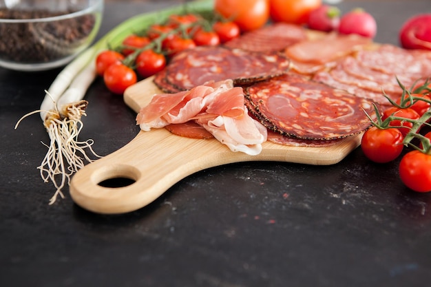 Schließen Sie oben auf unterschiedlichem köstlichem Fleisch auf hölzernem Brett im Studiofoto