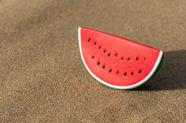 Schließen Sie oben auf Wassermelonenspielzeug auf Sand