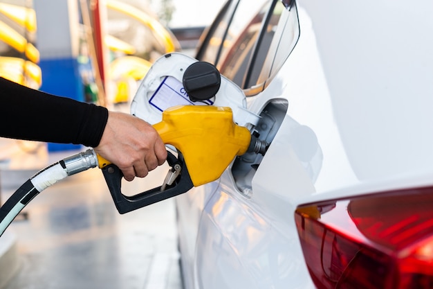 Schließen Sie oben das Pumpen der Benzinkraftstoffdüse im Tank für Auto an Tankstelle.