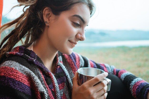 Schließen Sie oben eine Frau, die nach dem Aufwachen eine Tasse Kaffee trinkt