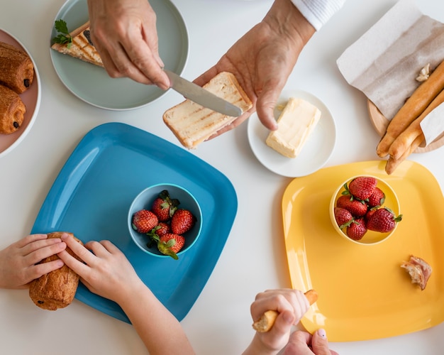 Schließen Sie oben Großeltern und Kind am Tisch