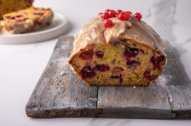 Schließen Sie oben hausgemachten Cupcake mit Preiselbeeren und Puderzucker auf Holzschneidebrett auf Licht