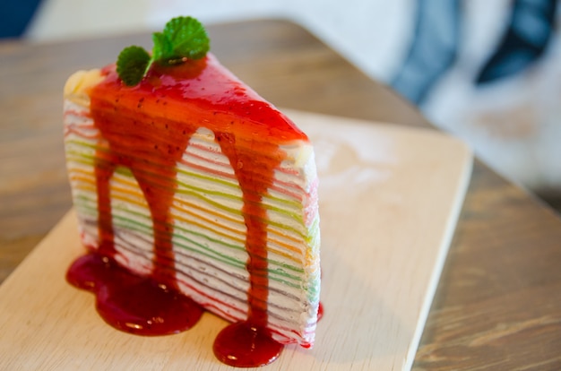 Foto schließen sie oben vom regenbogenkreppkuchen auf hölzerner platte