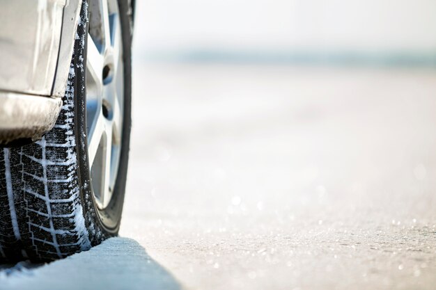 Schließen Sie oben von den Autoradgummireifen in der tiefen Winterschneestraße