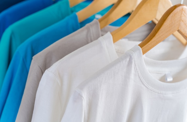 Schließen Sie oben von den bunten T-Shirts auf Aufhängern, Kleid