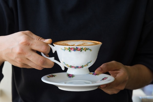 Schließen Sie oben von den Frauenhänden, die Weinlesetasse kaffee halten