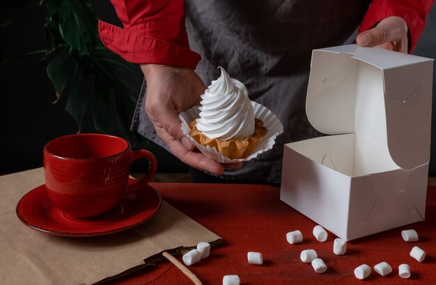 Schließen Sie oben von den Händen, die hausgemachtes Dessert halten