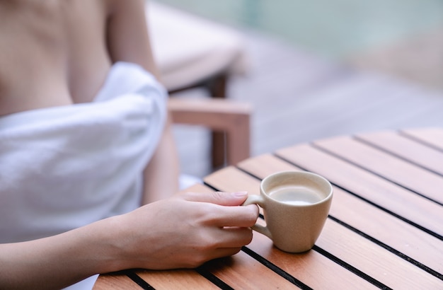 Schließen Sie oben von den sexy Brüsten der Frau, die mit Tasse Kaffee trinken. Morgen Kaffee.