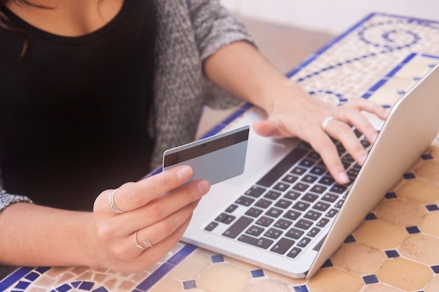 Schließen Sie oben von den weiblichen Händen, die on-line-Zahlung bilden. Frau, die an sitzt