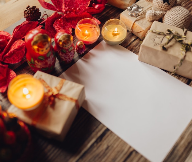 Schließen Sie oben von den Weihnachtskerzen mit Geschenken auf dem Tisch