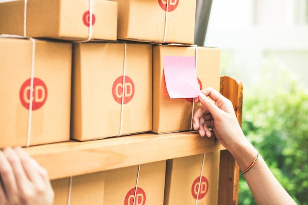 Schließen Sie oben von der Frauenhand, wenn Sie das Memo-Papier haften, um Briefkasten zu senden oder zu packen