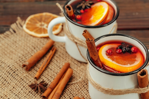 Schließen Sie oben von der Glühweinschale mit Gewürzen und Beeren auf grauer Tabelle