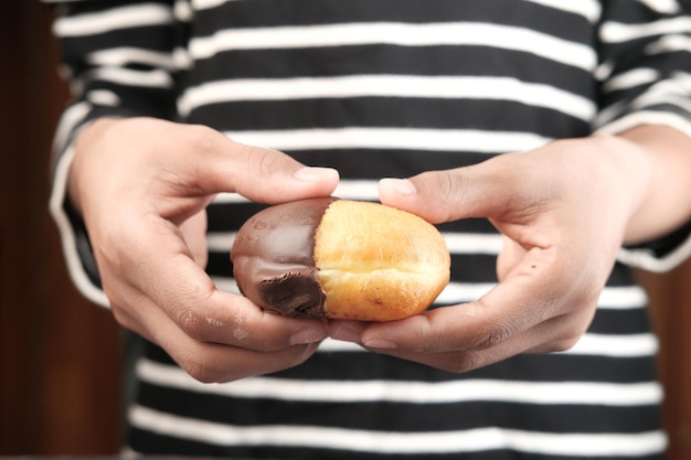 Schließen Sie oben von der Hand, die Donuts lokalisiert auf Weiß hält
