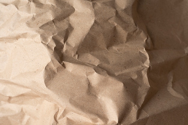 Schließen Sie oben von der recycelten braunen Faltenpapierstruktur für Hintergrund oder Design oder Kunstwerk. Draufsicht Nahaufnahme Papierhintergrund