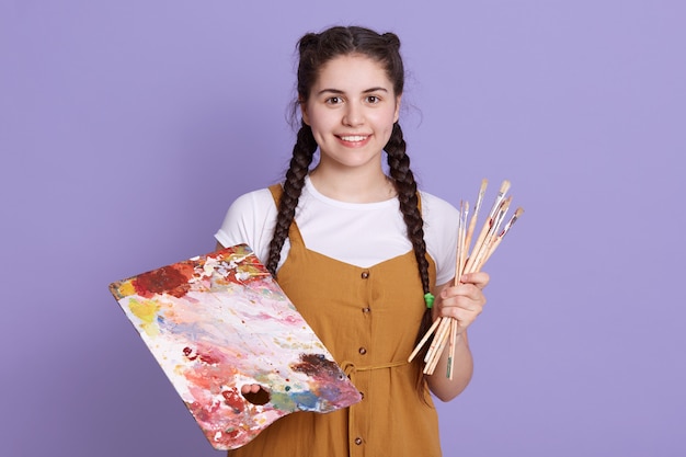 Schließen Sie oben von der schönen jungen kaukasischen jungen Frau Künstlerin mit Pinsel und Farbpalette