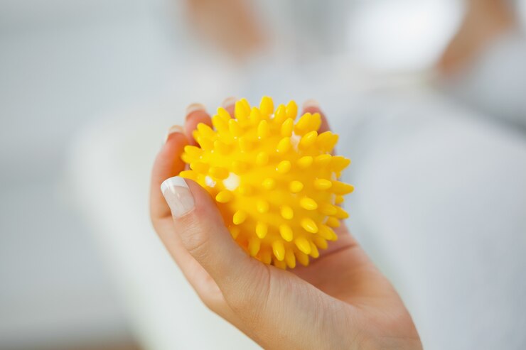 Foto schließen sie oben von der weiblichen hand, die gelben massageball hält