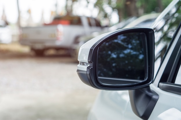 Schließen Sie oben von einem Flügelspiegel des weißen Autos