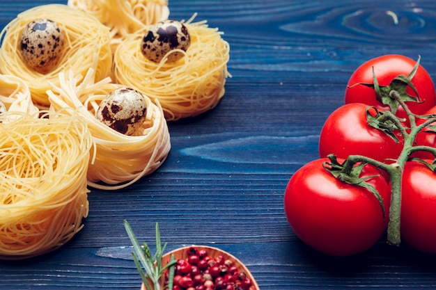 Schließen Sie oben von einem rohen trockenen italienischen Teigwarenfettuccine auf blauem hölzernem