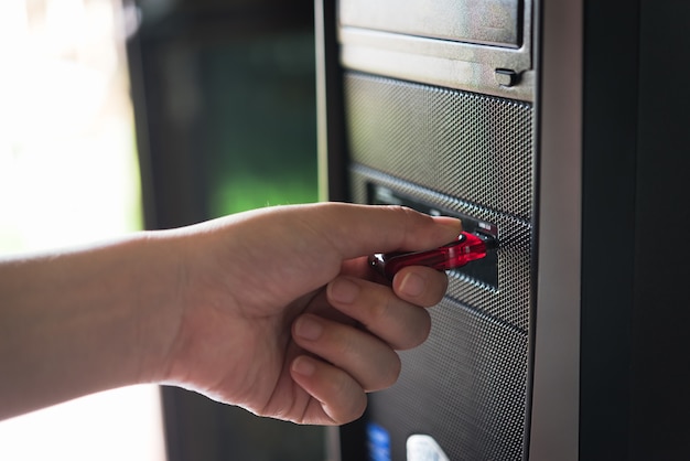 Schließen Sie oben von einer Frauenhand, die ein pendrive auf Computer verstopft