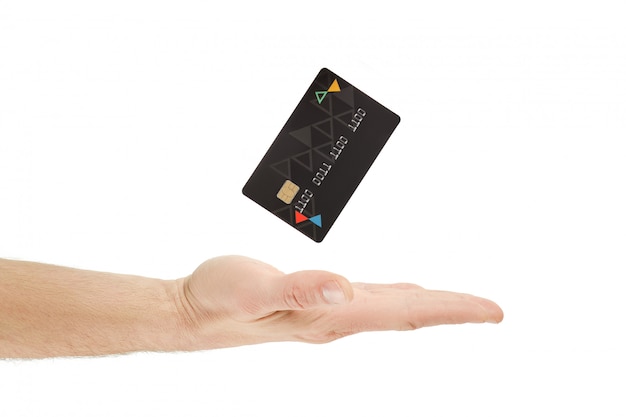 Schließen Sie oben von einer Hand, die eine schwarze Kreditkarte auf einem weißen Hintergrund hält