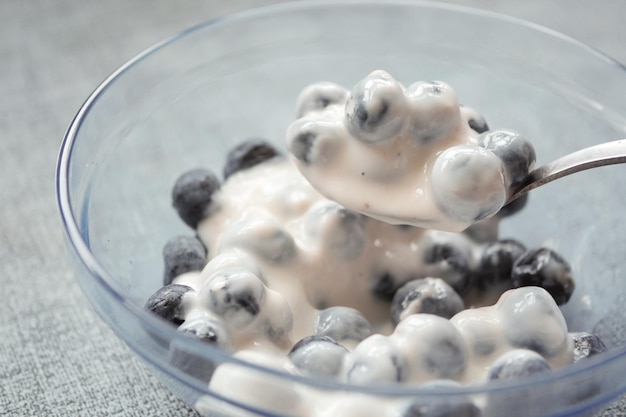 Schließen Sie oben von frischem Joghurt mit blauer Beere in einer Schüssel