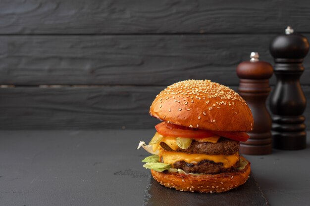 Schließen Sie oben von frischem leckerem Burger gegen schwarzen Hintergrund