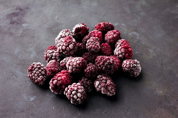 Schließen Sie oben von gefrorenen Brombeeren auf einem dunklen Hintergrund Gesundes Lebensmittelvitamin-Snack-Dessert