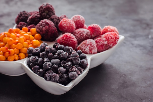 Schließen Sie oben von gefrorenen gemischten Früchten und Beeren auf einem schwarzen Tisch Gesundes Essen Vitamine Snack Dessert