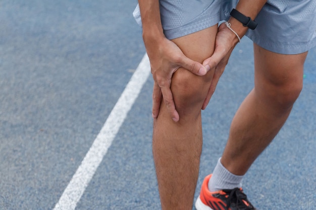Schließen Sie oben von Sportmann, der mit Schmerzen auf Sportlaufknieverletzung nach dem Laufen leidet. Verletzung vom Trainingskonzept.