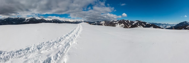 Schlittenspur und Fußabdrücke auf dem Winterberggipfel