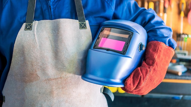 Schlosser in Spezialkleidung, Helm und Handschuhen für Arbeiten in der Produktion