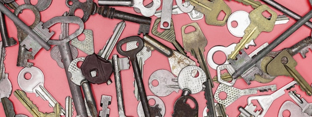 Schlüssel auf rosa Hintergrund gesetzt. Türschlossschlüssel und Safes für Eigentumssicherheit und Hausschutz. Verschiedene antike und neue Schlüsseltypen.